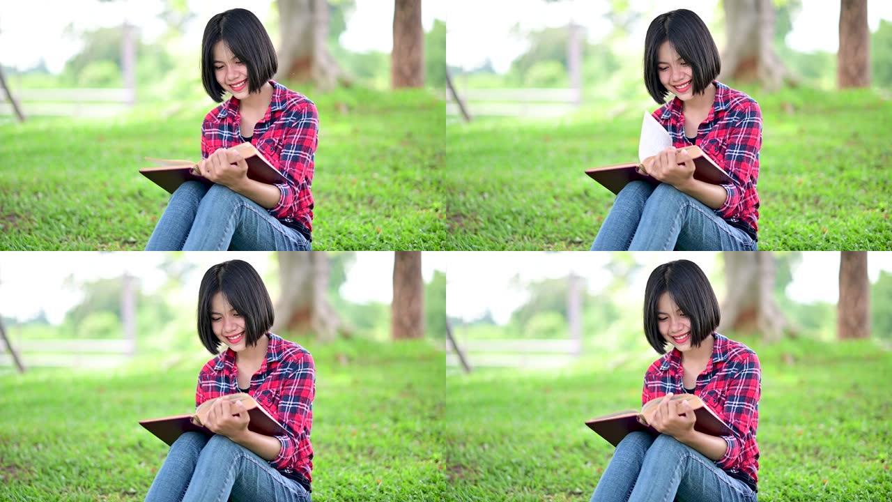 亚洲女人在公园的树下看书的概念增强对空闲时间阅读的热爱，获取知识，增长知识并增加良好的记忆4k视频