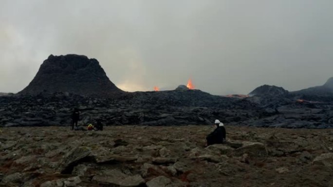 2个坐在火山外的人