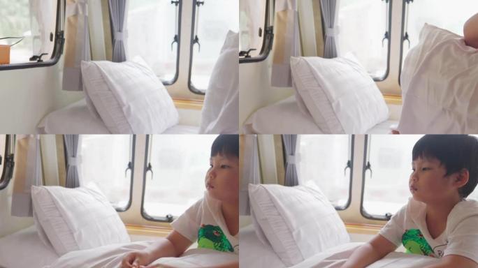 亚洲男孩正在一辆露营车上在线教室，窗外可以看到风景。范生活