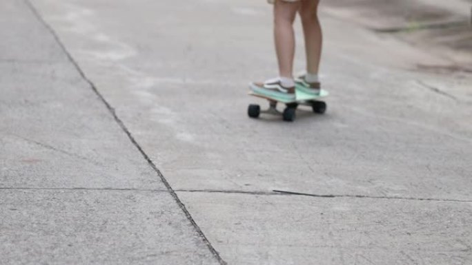 年轻成年女性在路上玩冲浪滑板