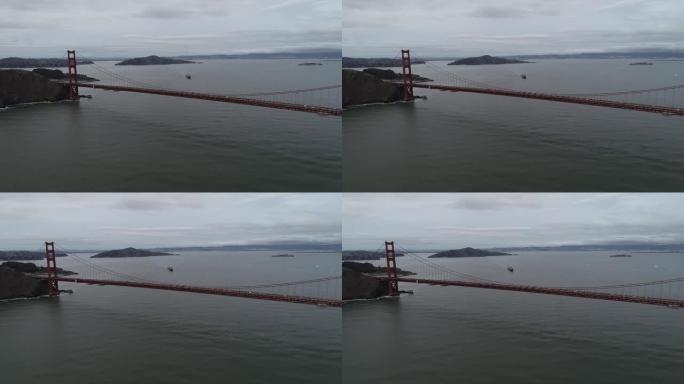 加利福尼亚州旧金山的金门大桥。多云的天空。恶魔岛和监狱，背景是集装箱船。美国