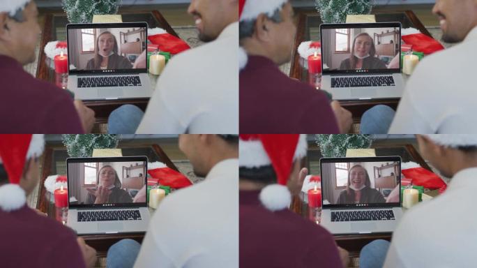 微笑的混血儿父子使用笔记本电脑与屏幕上的女人进行圣诞节视频通话
