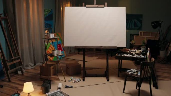 工作区，画家的工作室，带有大画架的艺术家，房间中间有画布。画布周围散落着油漆、刷子、纸箱，一片狼藉