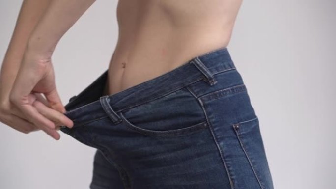 一位减肥的中年妇女测量的是已经变大的牛仔裤。