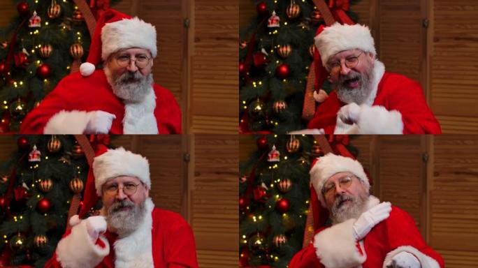 圣诞老人跳舞滑稽的肖像。老人留着红色西装，戴着帽子，在圣诞树的背景下戴着玩具和灯。新年快乐的夜晚。特