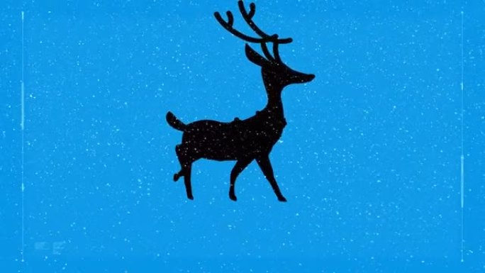 雪落在驯鹿在蓝色背景下行走的剪影上