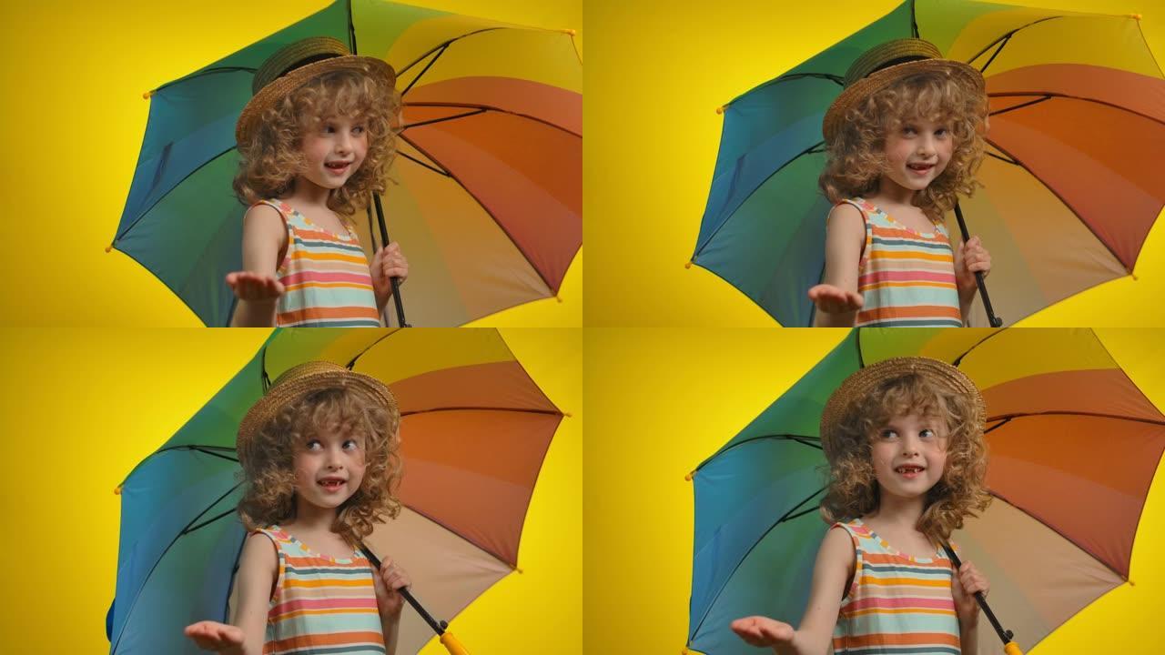 戴着彩虹伞的可爱的卷发金发女孩正在检查雨水
