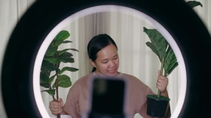 通过智能手机直播亚洲女性在家里卖植物的特写
