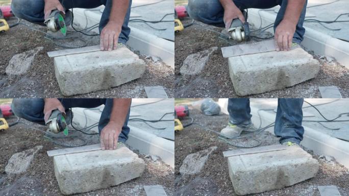 专业工人使用带锋利圆刀片的电动研磨机在施工现场切割瓷砖，没有防护手套的建筑商用研磨机切割瓷砖。危险