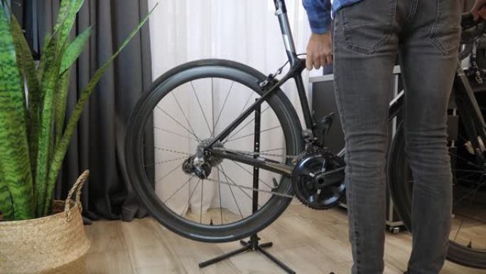自行车机械师在自行车车间把自行车放在架子上。自行车修理。修理厂