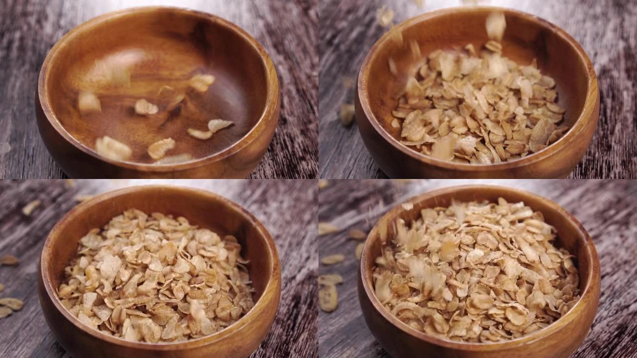 未煮熟的干谷物拼写小麦薄片落入粗糙的木制乡村碗中