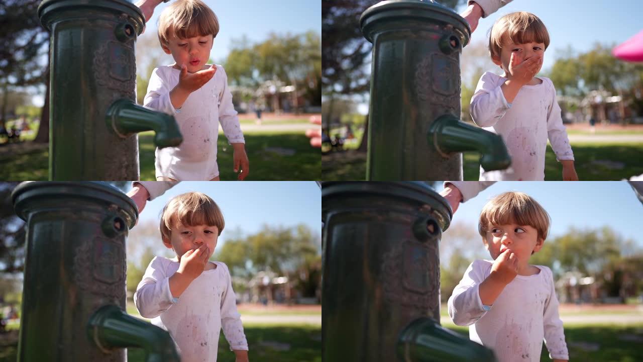 可爱的小孩在公园用干净的水龙头喝水