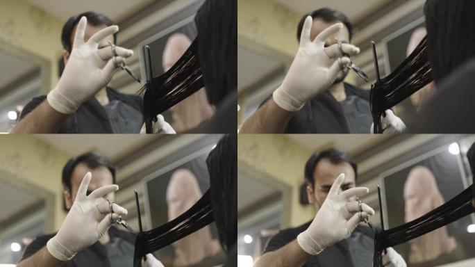 男性理发师用剪刀剪发女性头发的特写