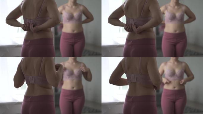 一名妇女在试衣间试穿胸罩，镜子中反射出带有宽扣的紧身胸衣