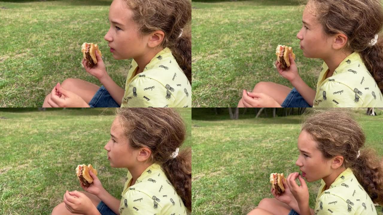 4k小女孩吃汉堡，在草坪上唱歌。