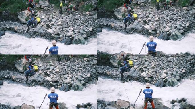 一名游客沿着用登山扣固定的垂直电缆过河。