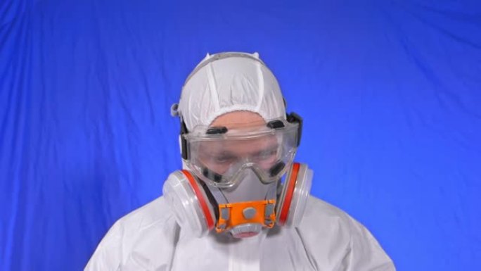 呼吸器中的疯狂科学病毒学家。慢动作。男子近距离看，戴着防护医用口罩。新型冠状病毒肺炎。色度键蓝色电影
