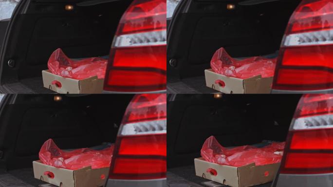 工人把一箱冷冻肉放在汽车后备箱里。4k视频