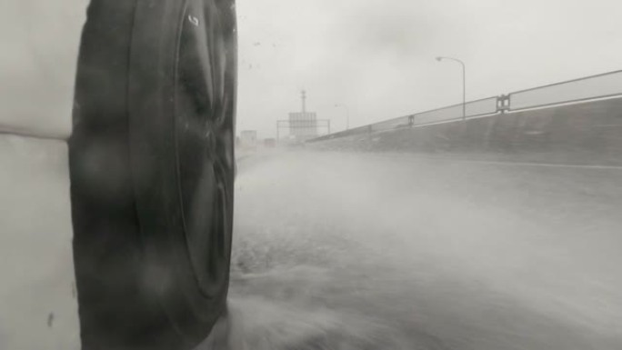 雨天在高速公路上行驶。汽车轮胎和飞溅的水。慢动作。