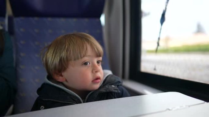 小男孩乘火车旅行，看着窗外做白日梦