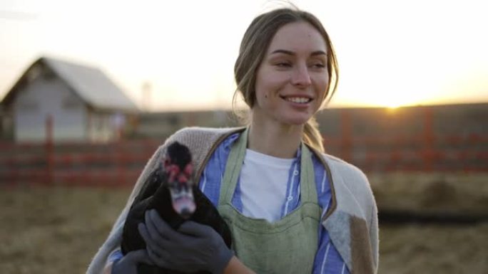 年轻女子在当地农场手持家鸭