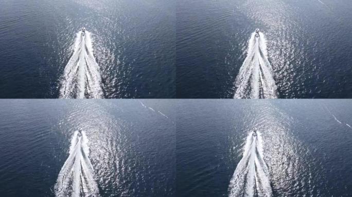 一艘快艇在蓝色大海的水面上向前冲。无人机在海景中的船。