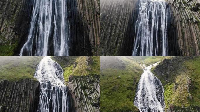 高山瀑布在黑色陡峭的岩石悬崖上