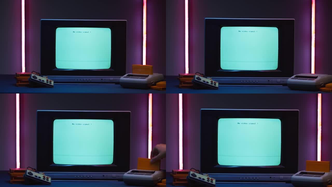 紫色霓虹灯背景上带有蓝屏的旧电视。老式电视和复古playstation的特写镜头，更换墨盒。古董视频