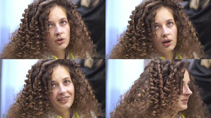 一位留着卷发的年轻女子的特写镜头正在整理头发，她一边看着镜头一边说话