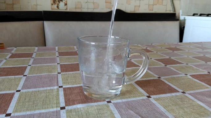 水被倒入厨房的透明玻璃中