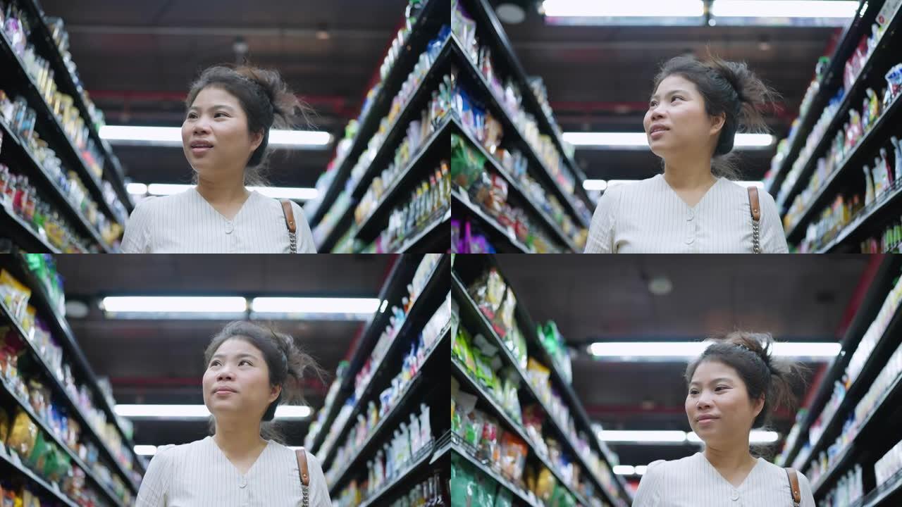 锁定结束，亚洲成年女性享受购物手拉购物车在百货商店的货架上检查消费品