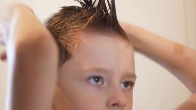 可爱的高加索男孩7-9岁做一个非常时髦的发型自己。这个孩子正在梳理自己，创造自己的风格。顽皮的年轻理