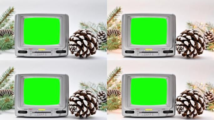 白色背景的绿色屏幕小老式电视为圣诞节装饰。绿色屏幕电视的圣诞节场景。停止运动