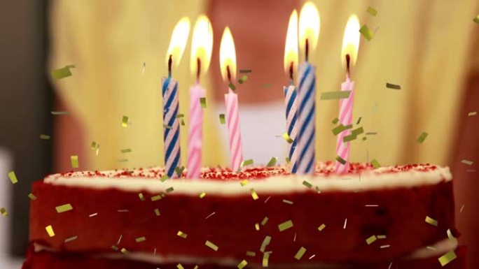 黄金五彩纸屑掉落在生日蛋糕上点燃的蜡烛上的动画