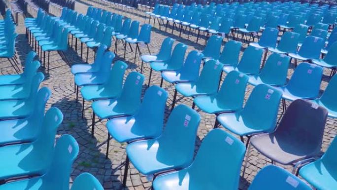 蓝色塑料椅子排成一排，用于观察事件