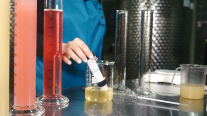 科学家将葡萄酒产品液体倒入试管中，进行质量控制。酿酒师实验室在酿酒厂实验室测试葡萄酒。测定酒精含量冷