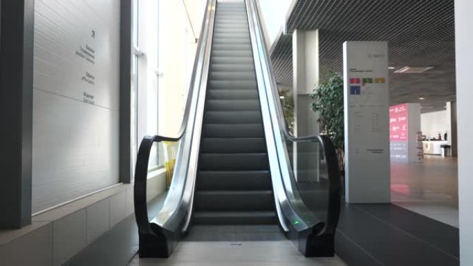 自动扶梯机构缓慢移动。HDR。带有白色墙壁和地板的现代商务中心的内部，建筑和设计的极简主义。