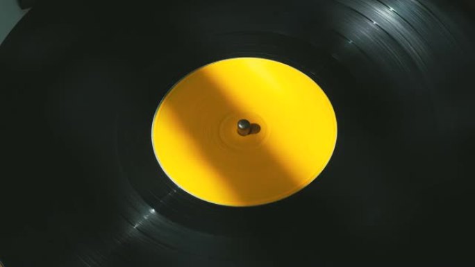 旧DJ转盘播放器上带有黄色标签的黑色乙烯基复古唱片旋转板。派对和流行迪斯科趋势上的老式旋转唱片特写。
