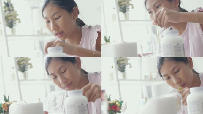 亚洲女孩通过智能手机制作视频，有关如何制作黏液或黏土的内容。新一代生活方式概念。