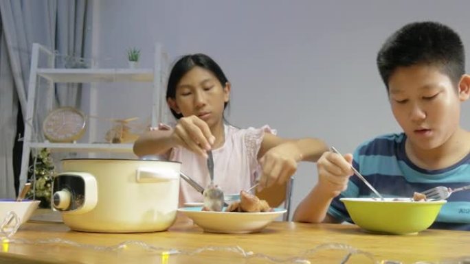 快乐的亚洲儿童在家里一起享用晚餐，简单的生活方式理念。