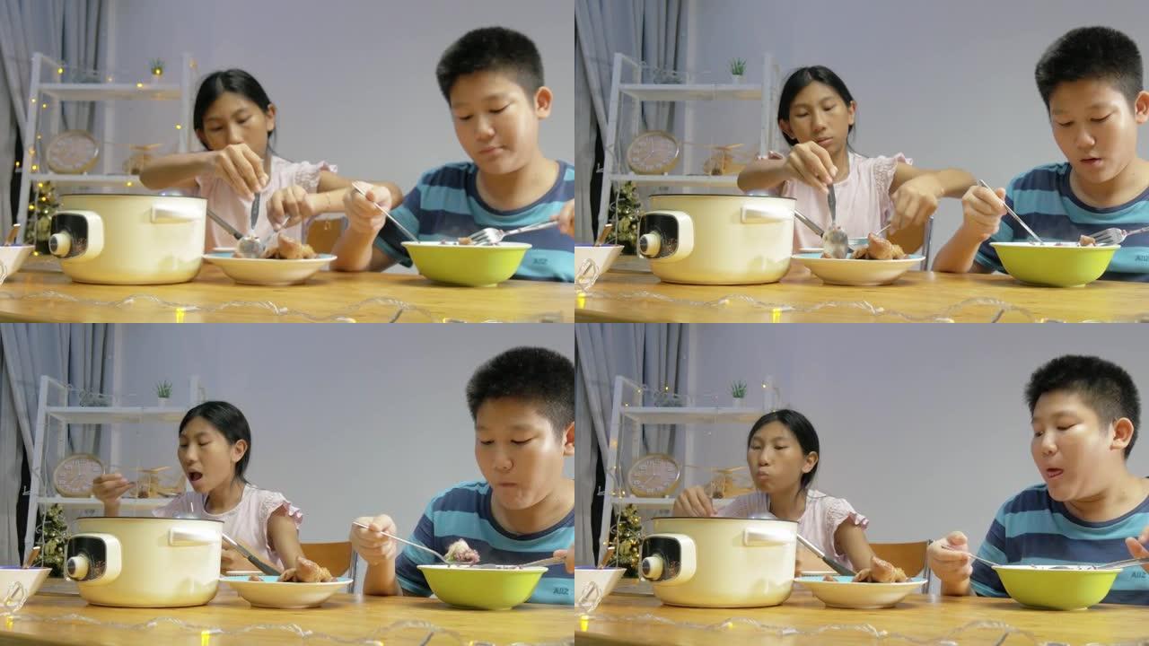 快乐的亚洲儿童在家里一起享用晚餐，简单的生活方式理念。