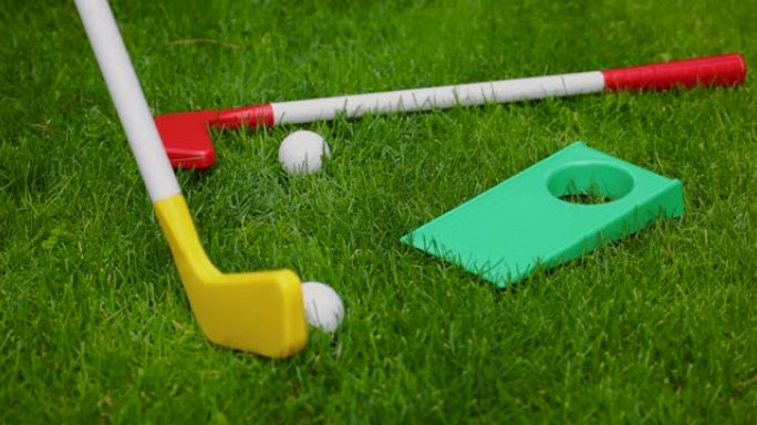 玩具高尔夫-用塑料高尔夫球杆将球击入洞中。花园游戏