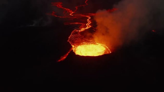 向前飞过活火山的火山口。喷发的热岩浆和流出的火山气体。夜间流动的熔岩流。法格拉达尔斯福杰尔火山。冰岛