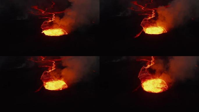 向前飞过活火山的火山口。喷发的热岩浆和流出的火山气体。夜间流动的熔岩流。法格拉达尔斯福杰尔火山。冰岛