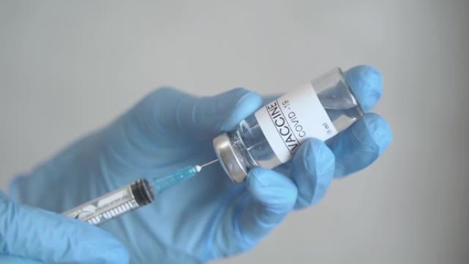 医生把冠状病毒疫苗抽到注射器里。
