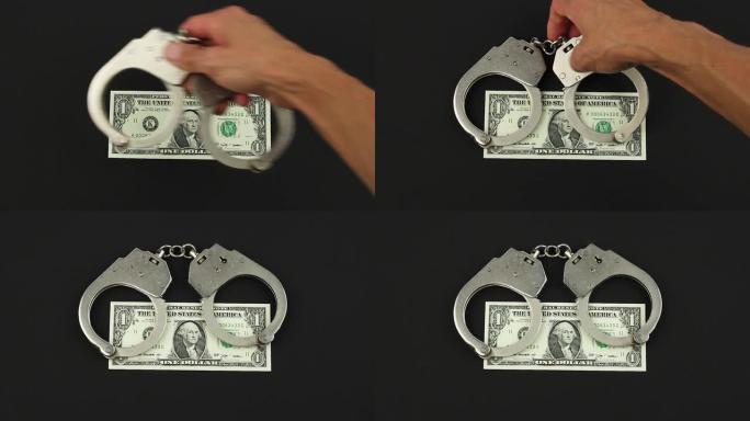 汉德把手铐戴在一美元钞票上的黑色背景，金融犯罪或腐败的概念