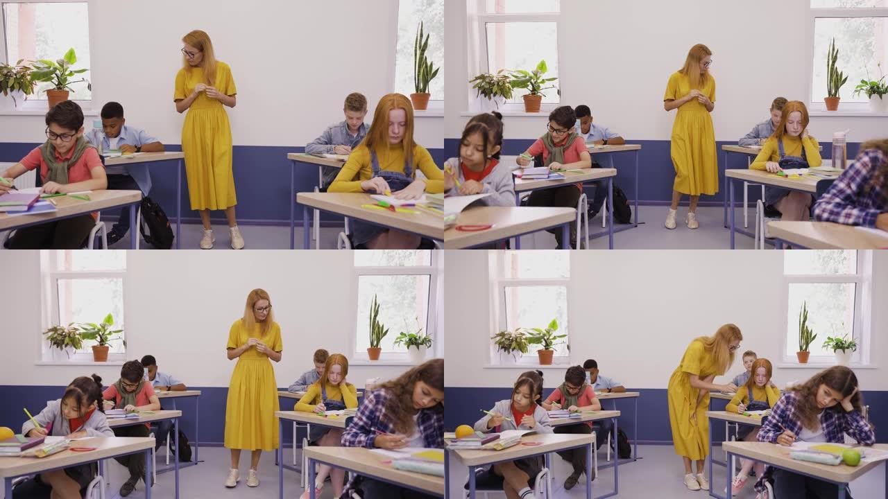 女老师帮助勤奋的学生在小学写测试