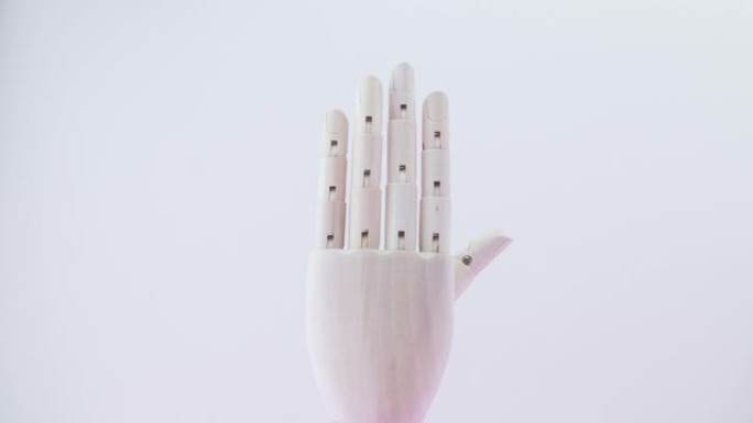 4k停止运动，用一只手的关键帧，一个木制木偶，举起5个手指而不是一个手符号。手语交流