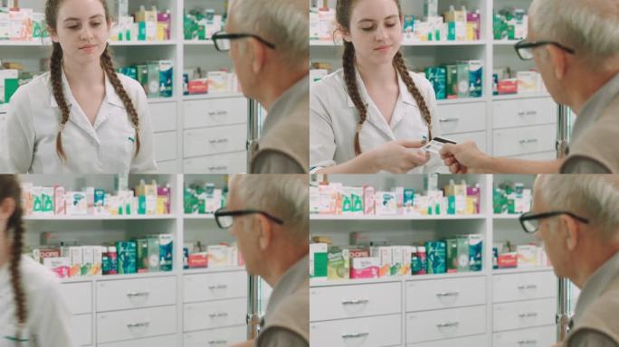 老人在药房用信用卡向一位年轻的女药剂师付款。