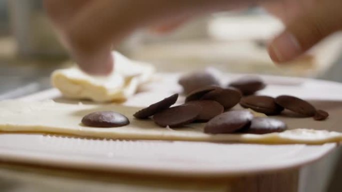 孩子的手在家用巧克力做酥皮面团，生活方式概念。